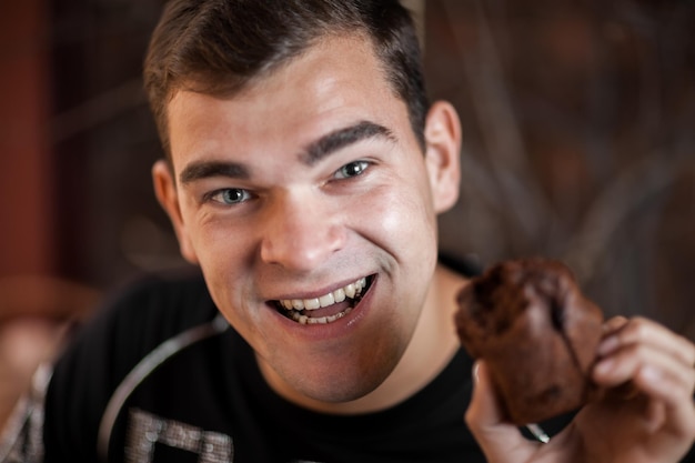 Photo portrait of smiling man having cake in home