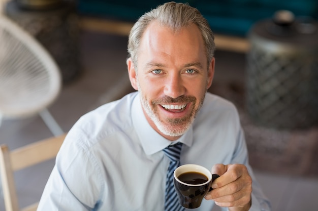 Portrait of smiling man having cup of coffee