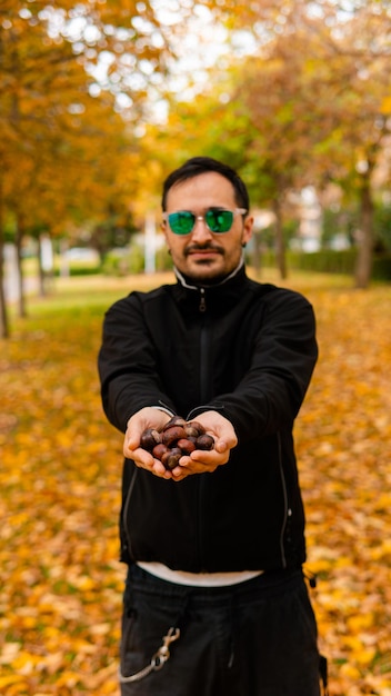 Portrait of smiling man holding leaves during autumn