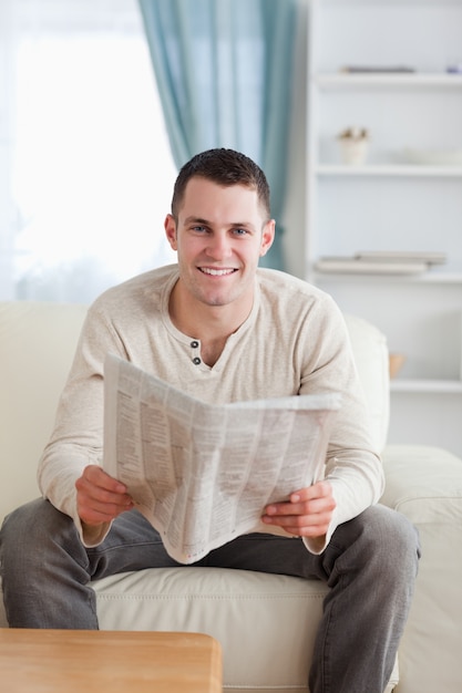 Foto ritratto di un uomo sorridente che tiene un giornale