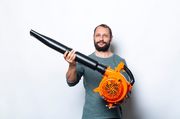 Foto il ritratto dell'uomo sorridente tiene nella macchina del ventilatore delle mani