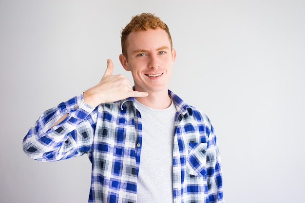 Foto ritratto dell'uomo sorridente che mostra chiamando gesto