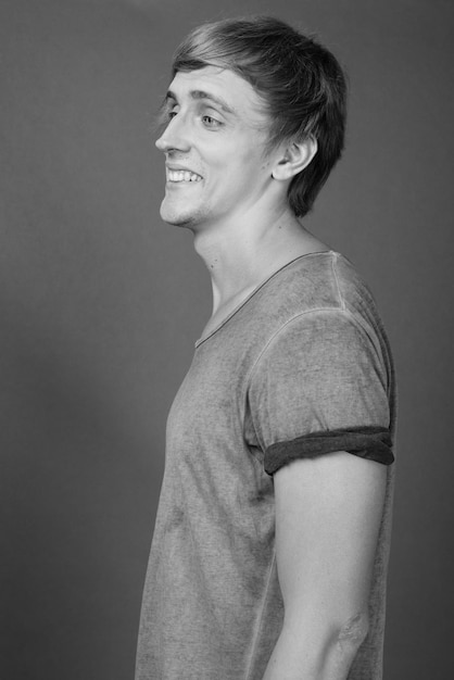 Photo portrait of smiling man standing against gray background