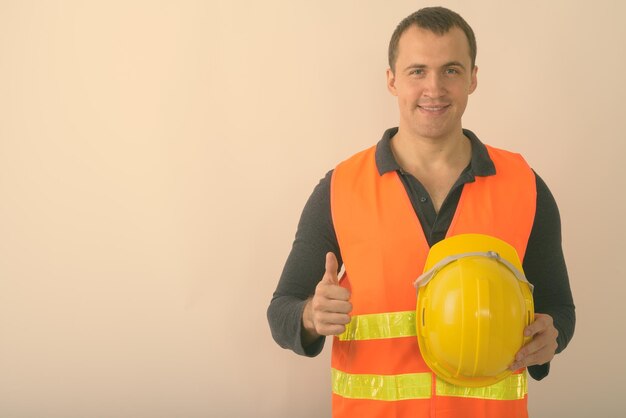 Portrait of smiling man standing against orange background