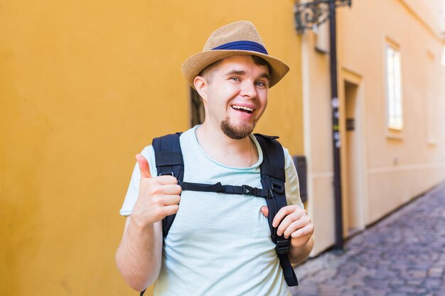 Foto ritratto di un uomo sorridente in piedi contro un muro giallo