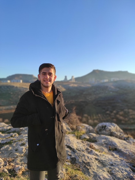 Photo portrait of smiling man standing on mountain against sky