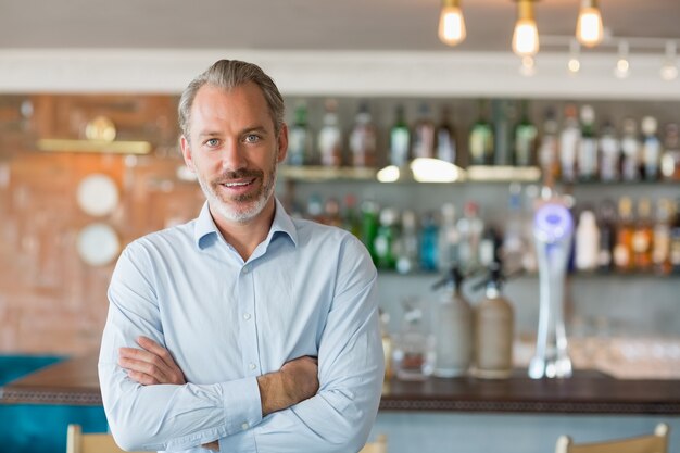 Portrait of smiling man standing with arms crossed