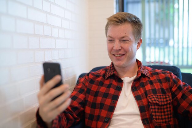 Photo portrait of smiling man using mobile phone