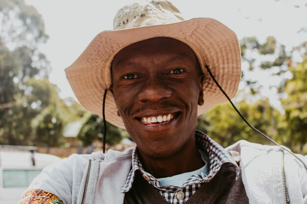 Photo portrait of smiling man wearing hat outdoors