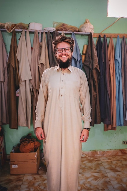 Photo portrait of smiling man wearing traditional clothing while standing at home