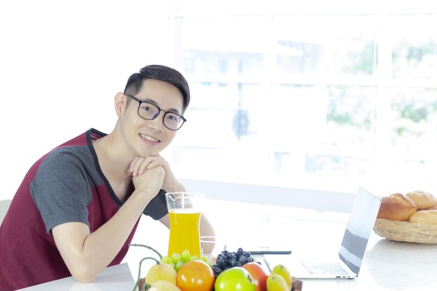 Portrait of smiling man with fruits on table