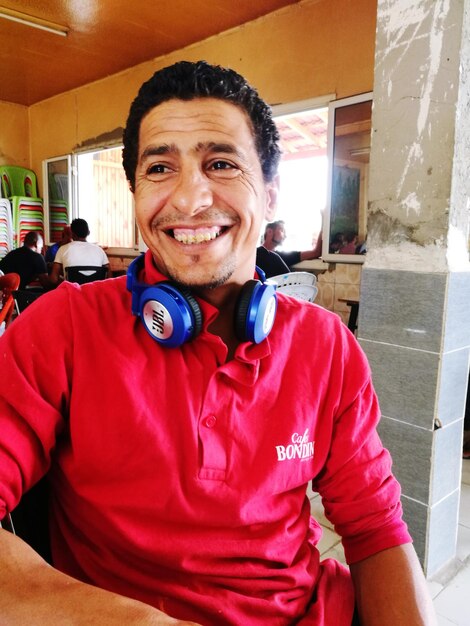 Photo portrait of smiling man with headphones at restaurant