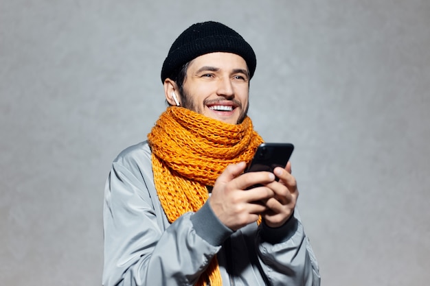 Портрет улыбающегося человека со смартфоном в руке