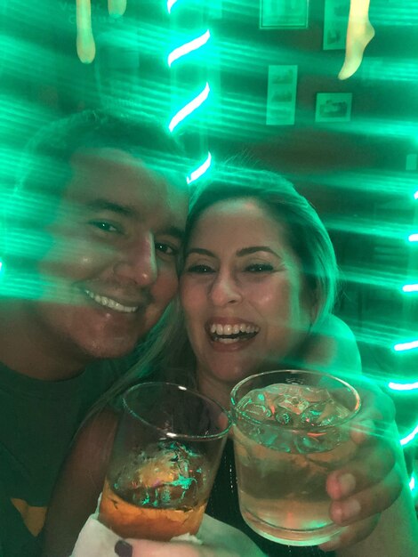 Photo portrait of smiling man and woman holding drink in glasses