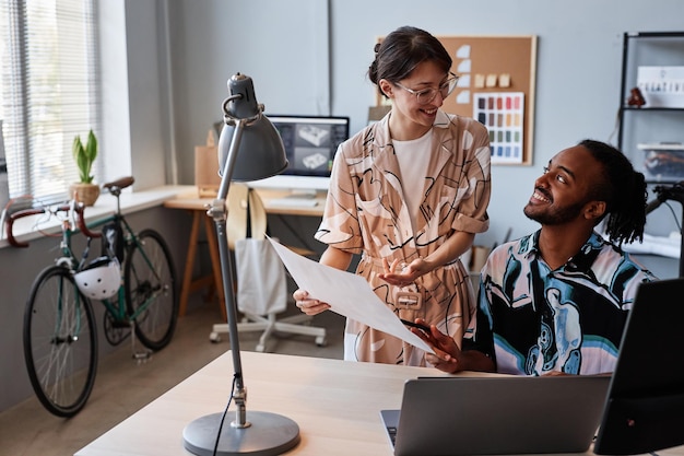 Portrait of smiling man and woman sharing ideas on creative design project in office setting