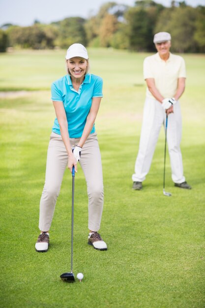Портрет улыбающиеся зрелые пары, играя в гольф