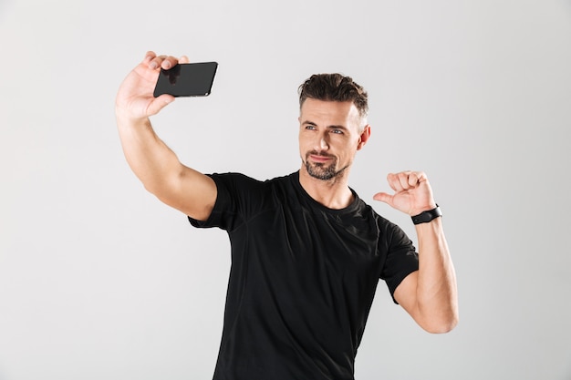 Ritratto di uno sportivo maturo sorridente che prende un selfie