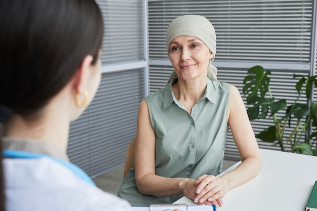 Photo portrait of smiling mature woman talking to female doctor during consultation in clinic, copy space