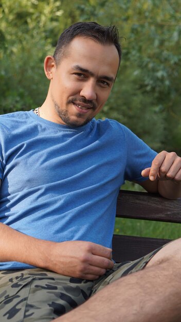 Photo portrait of smiling mid adult man sitting in park