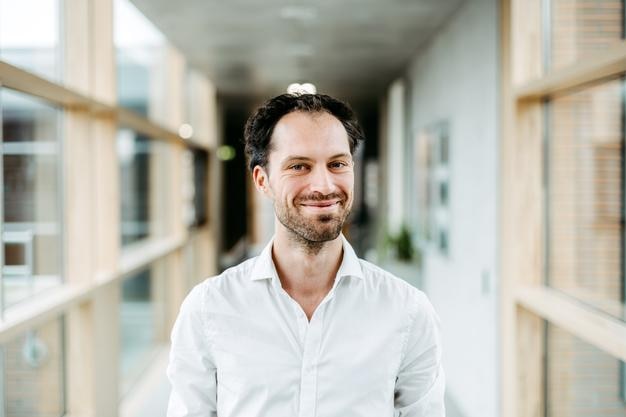 portrait of smiling mid adult man standing in corridor
