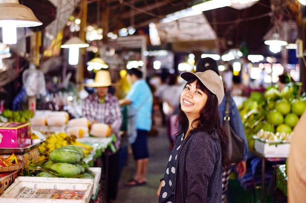 Photo portrait of smiling mid adult woman standing at market stall