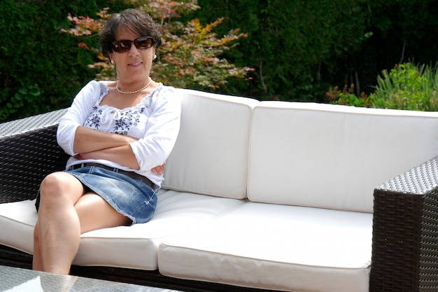 Portrait of  smiling middle age woman sitting in garden at home