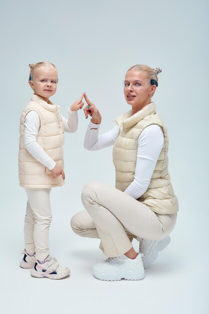 Portrait of smiling mother and daughter against white background