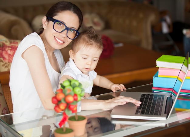 Photo portrait of smiling mother holding cute baby son at home