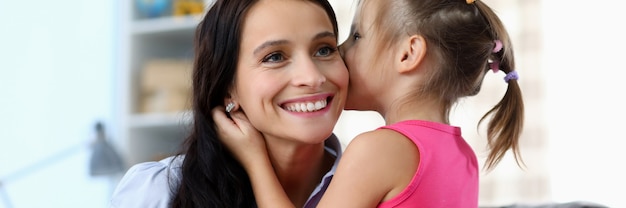 Portrait of smiling mother listening to daughter.