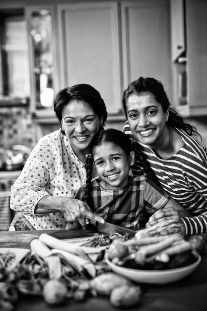 Photo portrait of smiling multi-generation family preparing food in kitchen