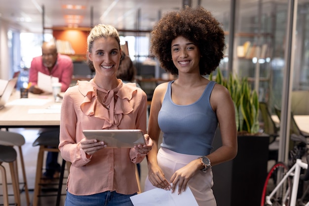 Photo portrait of smiling multiracial businesswomen working together at modern workplace