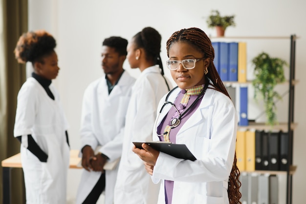 Portrait of a smiling nurse in front of her medical team