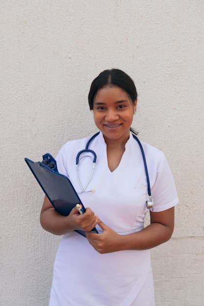 Portrait of smiling nurse with clipboard working in hospital