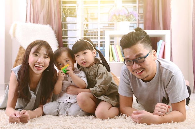 Photo portrait of smiling parents with children on carpet at home