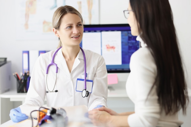 Portrait of smiling physician looking at woman patient with happiness