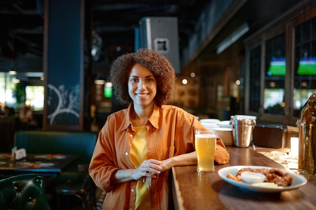 Portrait of smiling pretty woman at sports bar counter desk