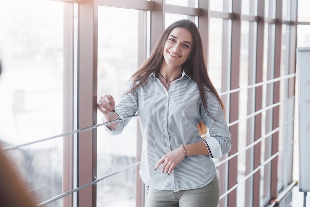 Portrait of smiling pretty young business woman on workplace