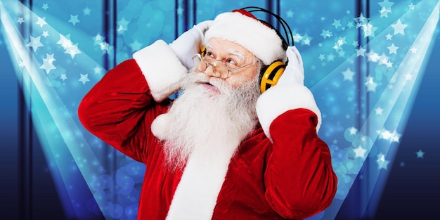 Portrait of smiling santa claus in headphones on background