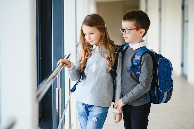 本と学校の廊下で笑顔の学校の子供たちの肖像画