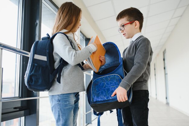 本と学校の廊下で笑顔の学校の子供たちの肖像画