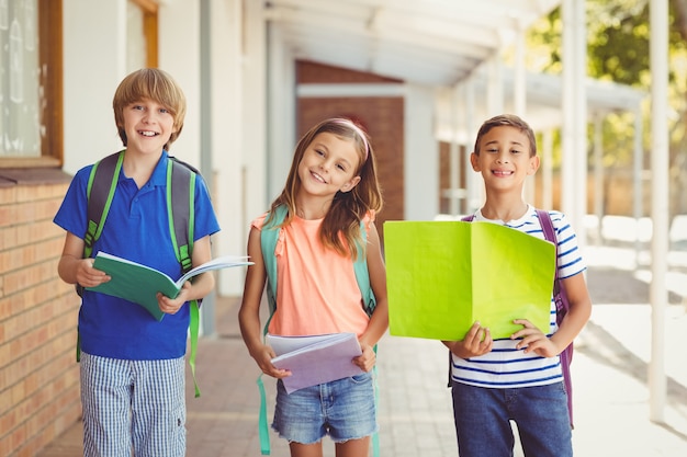 学校の廊下に立っている学校の子供たちの笑顔の肖像画