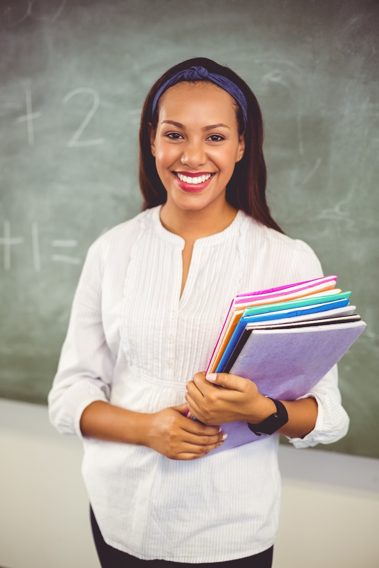 Photo portrait of smiling school teacher holding books in classroom