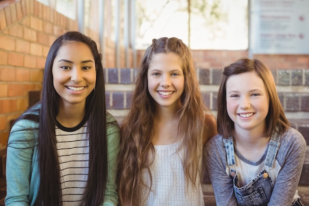 Portrait of smiling schoolgirls sitting on the staircase