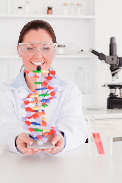 Portrait of a smiling scientist showing the dna double helix model