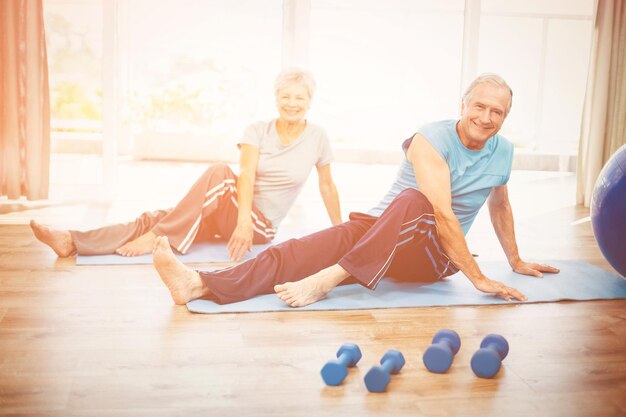 Portrait of smiling senior couple doing yoga