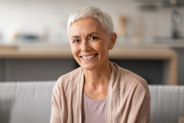 Portrait of smiling senior lady with gray short hair indoors