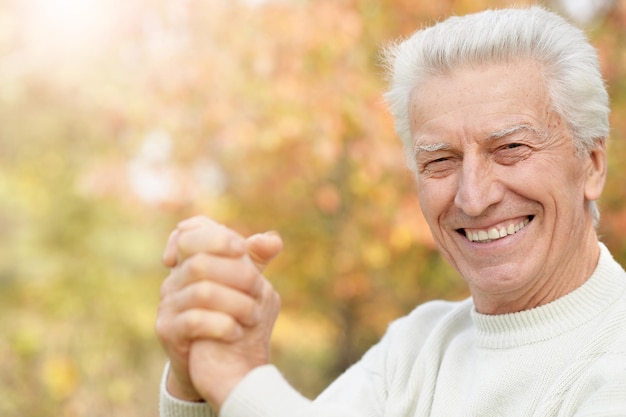 Photo portrait of smiling senior man in park