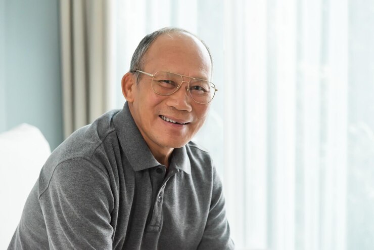Photo portrait of smiling senior man sitting at home