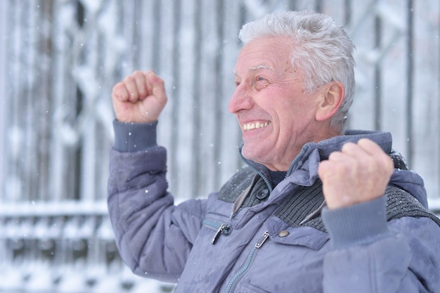 Portrait of smiling senior man standing outdoors