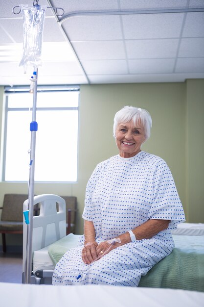 Portrait of smiling senior patient on bed